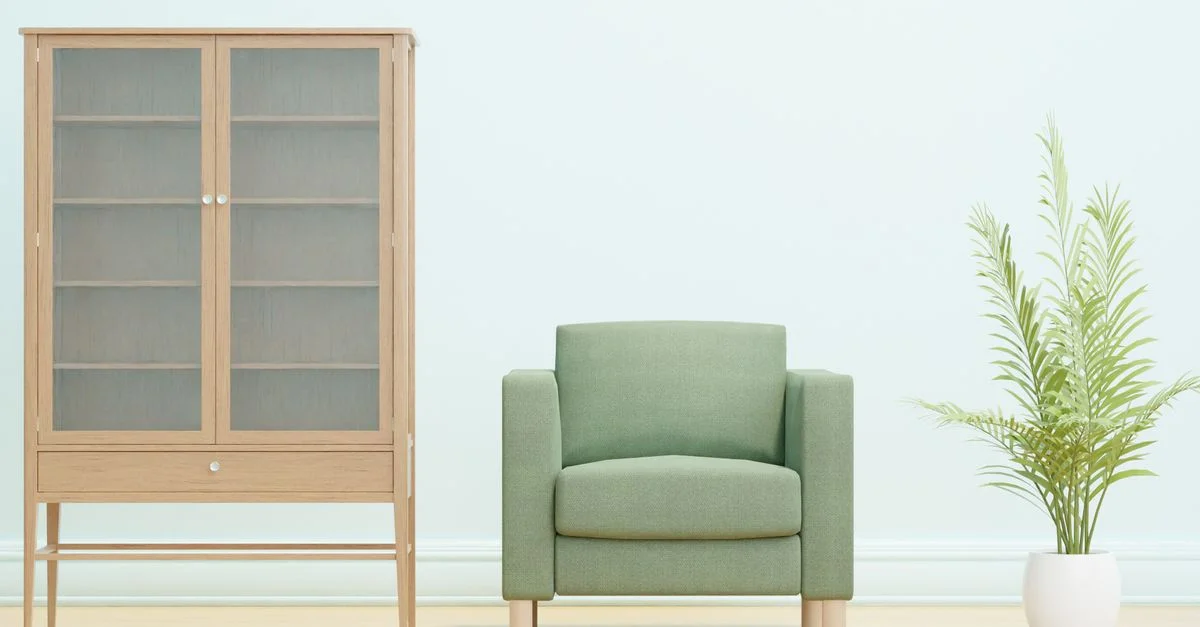 Intérieur minimaliste simple et élégant avec un fauteuil vert, une armoire en bois et une plante en pot.