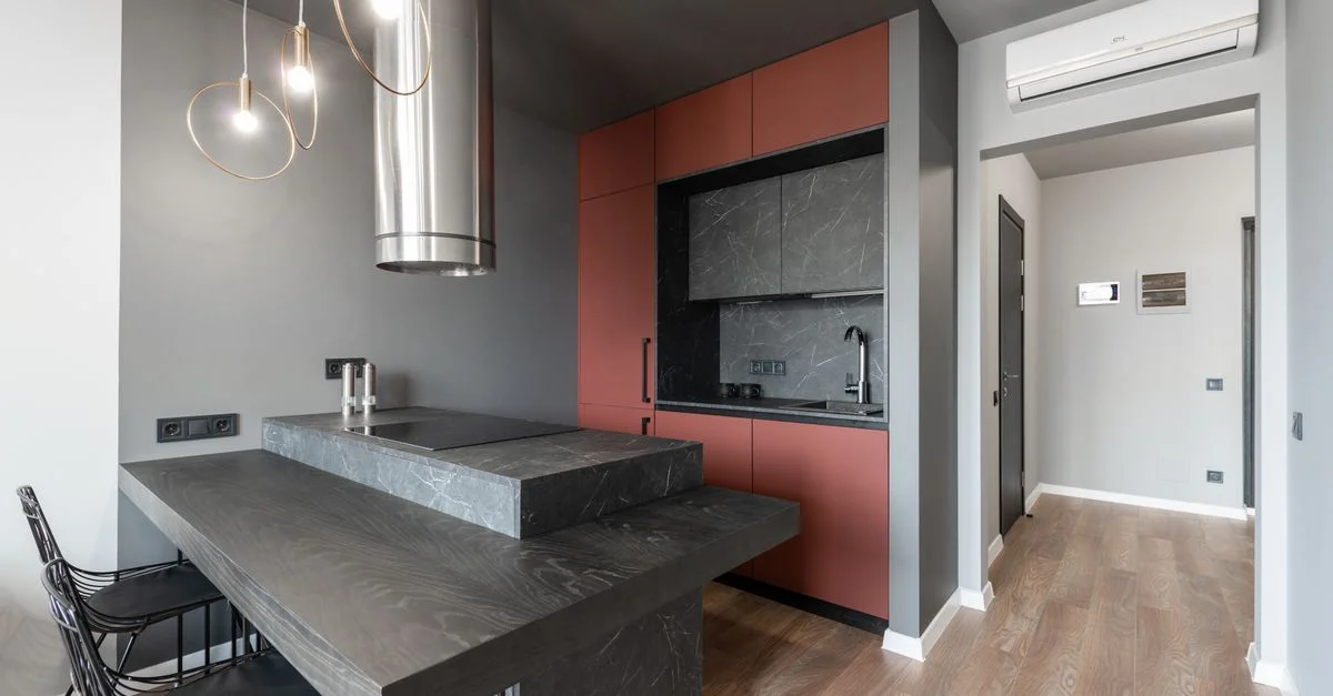 Intérieur de cuisine contemporain avec des comptoirs en marbre noir et un éclairage élégant.