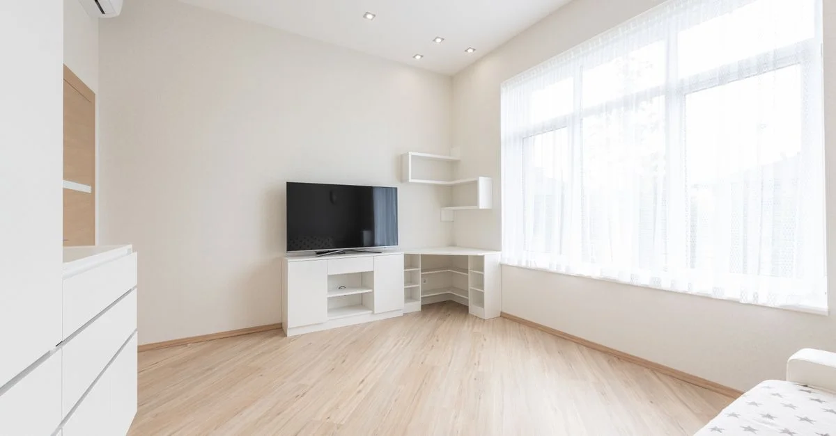 Salon lumineux et minimaliste avec des meubles élégants et de grandes fenêtres.