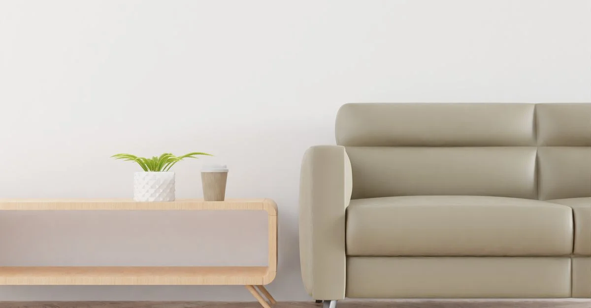 Salon moderne avec un canapé beige, une plante et une tasse à café sur une table en bois élégante.